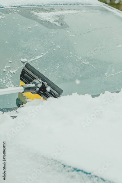Obraz Brushing Snow Off a Car Windshield in Winter