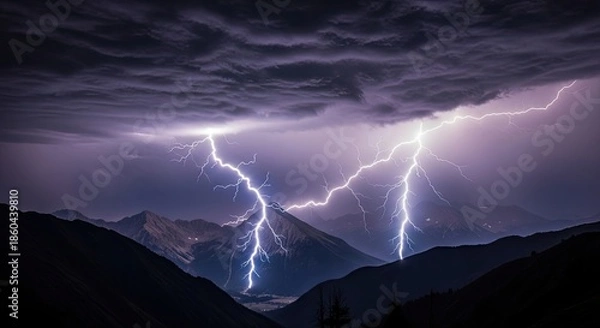 Obraz A dramatic lightning storm over a mountain range at night.