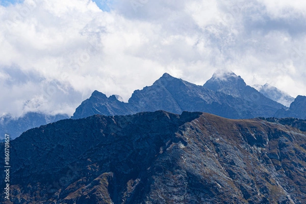Obraz Mountain peak emerging through clouds with dramatic alpine atmosphere