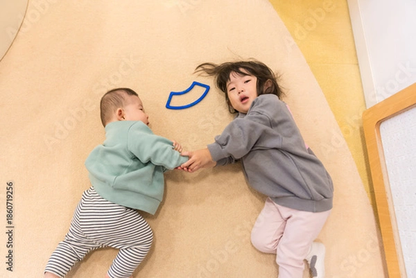Obraz マンションのキッズルームで遊ぶ日本人の小さい姉弟