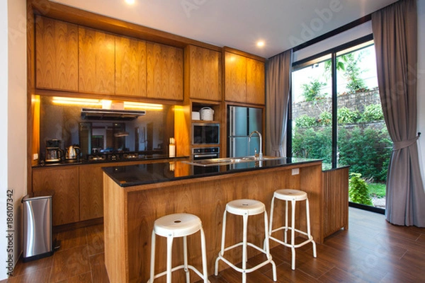 Fototapeta Luxury interior design pool villa in kitchen area which feature island counter and built in furniture
