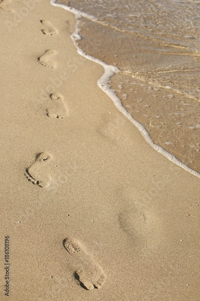 Obraz beach, wave and footsteps at sunset time
