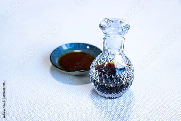 Obraz ガラス製の醤油差しと醤油が注がれた丸い小皿
