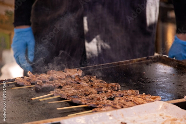 Obraz 屋台の鉄板で焼かれる串焼きの肉
