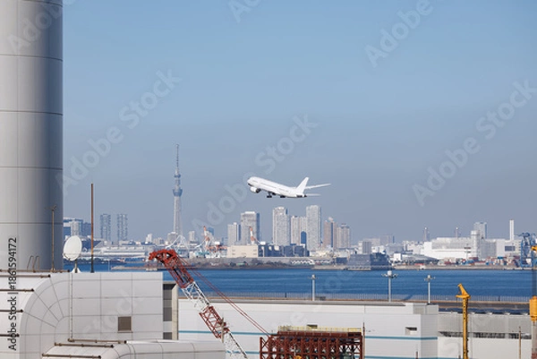 Obraz 羽田空港、第一ターミナルから見た第二ターミナル超しに見える離陸する旅客機