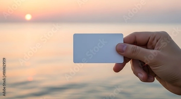 Obraz Blank Card Held Against a Sunset Ocean Backdrop.