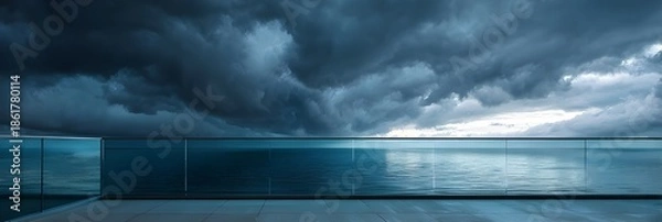 Obraz Modern frameless glass railing mirroring dramatic storm clouds above ocean architectural photography design exterior scene