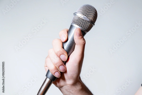 Obraz hand holding microphone against a white background