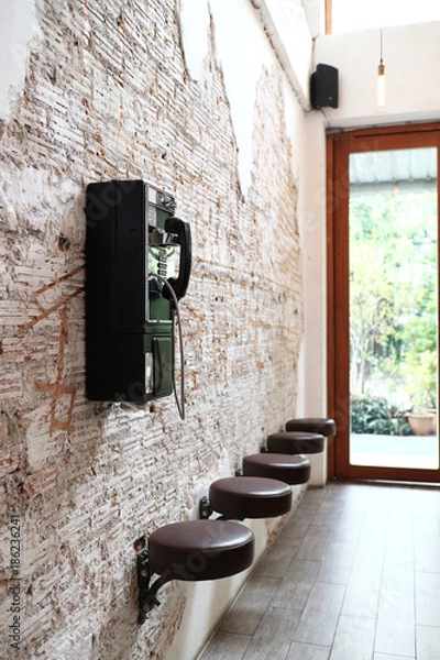Fototapeta ancient vintage telephone hanging on bricks wall