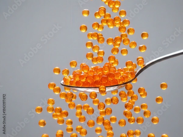 Obraz Orange caviar falling from a spoon in a dynamic studio shot