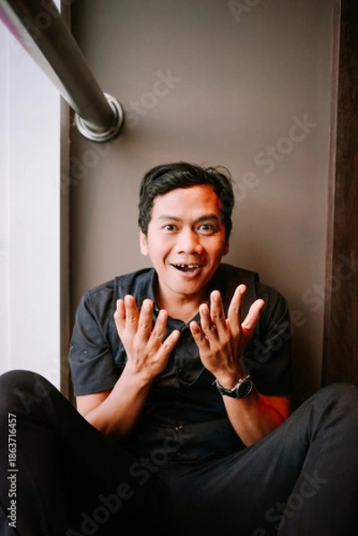 Obraz Expressive Young Man Gesturing Hands with Surprised Smile