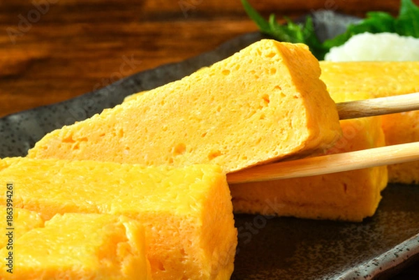 Fototapeta だし巻き卵を持ち上げる