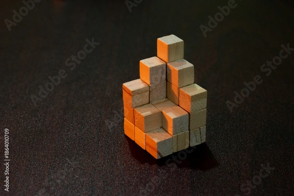 Obraz Small Wooden Block Built from Tiny Cubes on Dark Surface for Creativity.