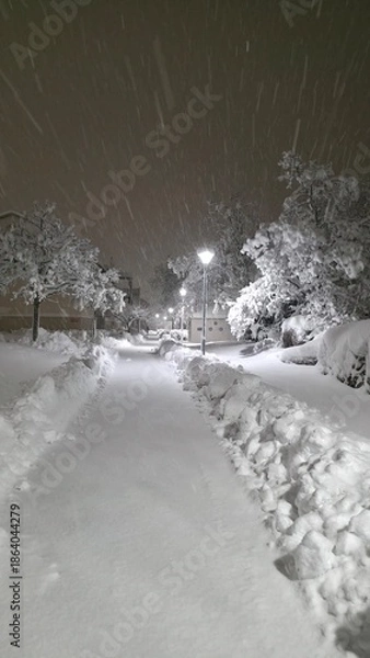 Obraz Snow covers a quiet path at night with streetlight casting a glow in a snowy landscape
