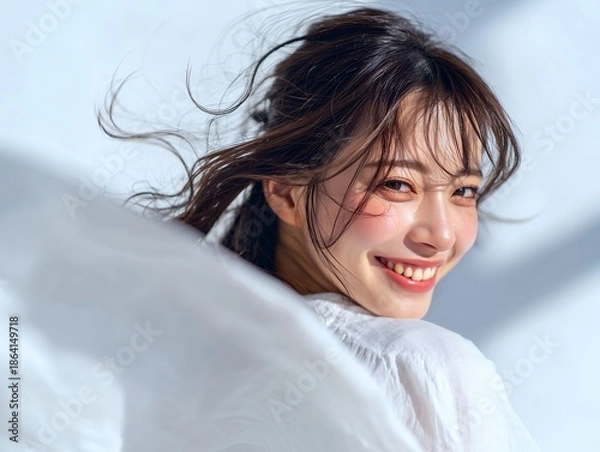 Fototapeta 青空の下で振り返り笑顔を見せる若者女性の爽やかなライフスタイルシーン