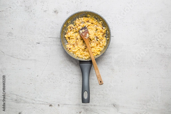 Fototapeta Ham and eggs. Scrambled eggs with bacon in ceramic pan