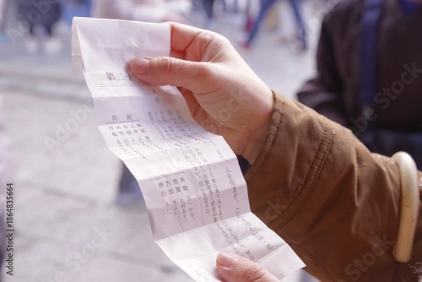 Fototapeta 神社のおみくじで運勢を占う女性の手元