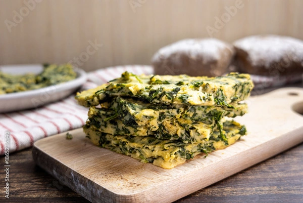 Obraz Spinach farinata with bread and kitchen towels
