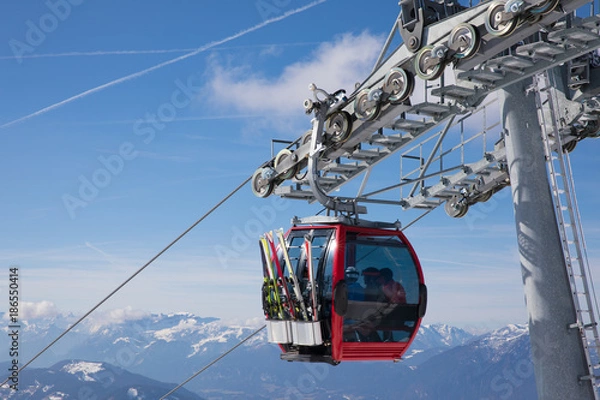 Obraz  some skiing peole are going with a funicular chair lift to the top of the mountain to do some wintersport