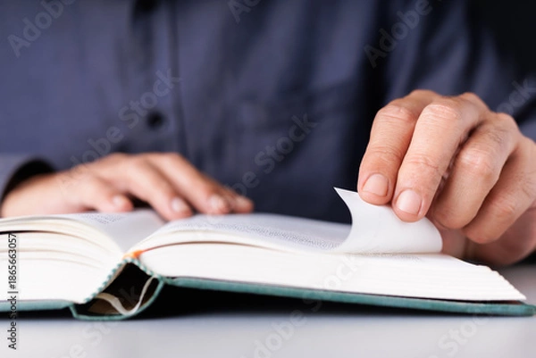 Obraz Man Folding Book Page to Mark Important Content While Reading