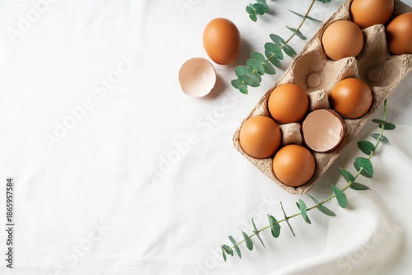 Fototapeta Easter concept background with brown eggs, eucalyptus leaves
