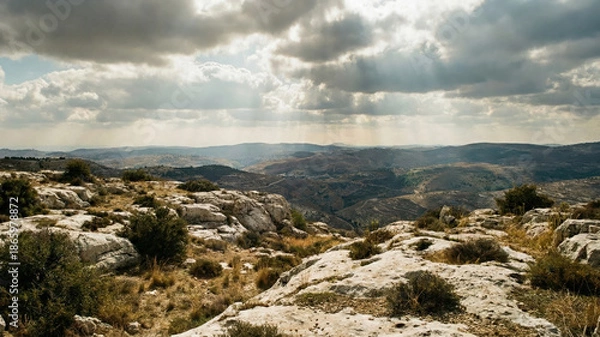 Obraz Dramatic clouds and sun rays over rocky mountains