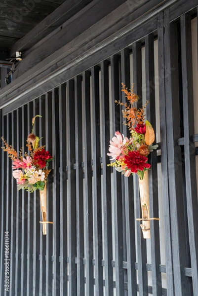 Obraz 古い街並みの格子に飾られた花束
