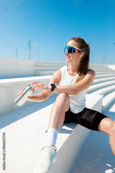 Obraz Athlete resting on steps during outdoor training session