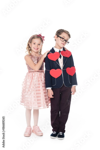 Fototapeta happy little girl embracing upset boy tied with rope and red hearts isolated on white
