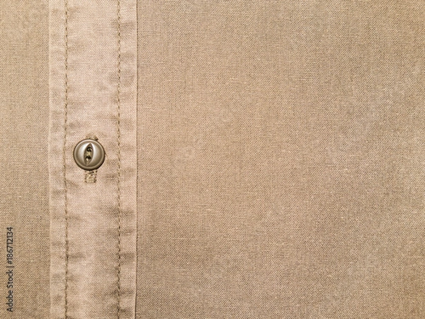 Fototapeta plain beige cotton shirt texture with button in close up