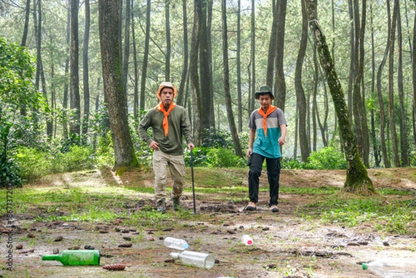 Obraz Two Hikers Discover Trash While Exploring Forest