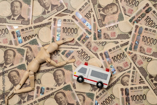Fototapeta 倒れた人形と救急車と敷き詰められた一万円札