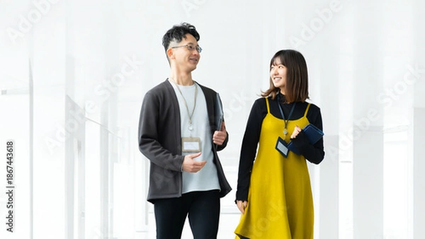 Obraz オフィスを歩きながら話す男女2人のビジネスマン