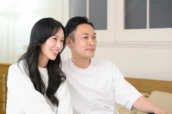 Obraz 夜の寝室で笑顔で会話をする日本人男女