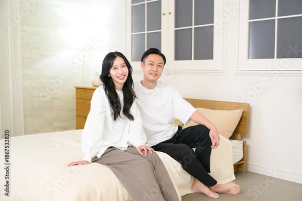 Obraz 夜の寝室で笑顔で会話をする日本人男女