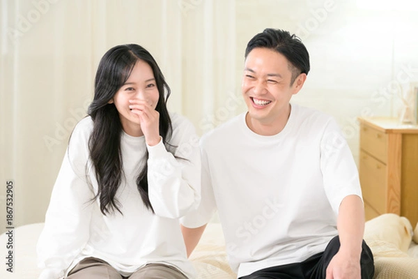 Obraz 夜の寝室で笑顔で会話をする日本人男女