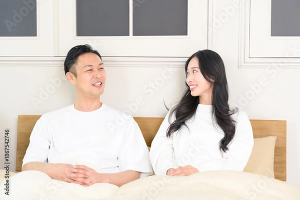 Obraz 夜の寝室で笑顔で会話をする日本人男女
