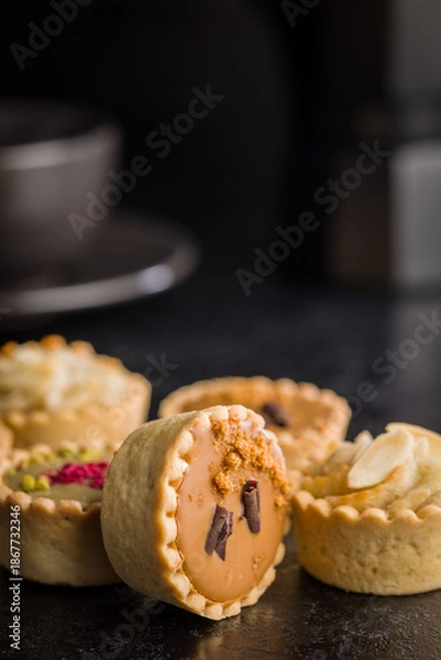 Obraz Sweet mini tartlets on black table.