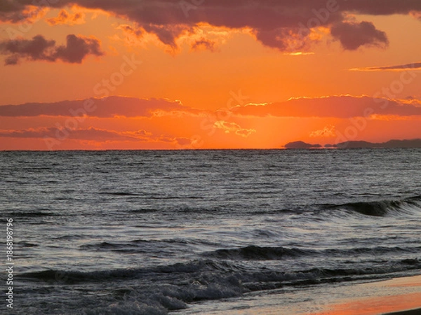 Fototapeta 日が沈んだ後の空模様と穏やかな波打ち際