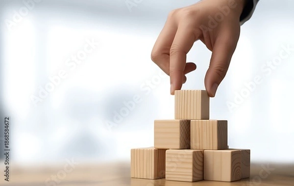 Obraz Hand stacking wooden blocks to build a stable structure