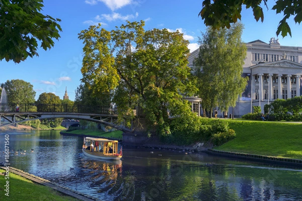 Fototapeta A boat with tourists on the canal of Riga