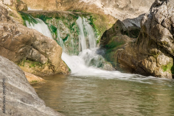 Obraz Small mountain waterfall on the rocks covered with moss deep in the forest. Cliffs in Cheile Turzii, Romania. Autumn is coming. Beautiful, calming nature background