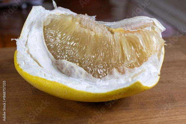 Obraz A peeled grapefruit slice. An orange slice on the table.
