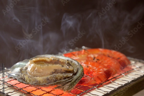 Obraz 煙り立ち昇る七輪でアワビと海老を焼く