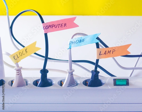 Obraz ?onvenient life hack with stickers on the wires inserted into the socket