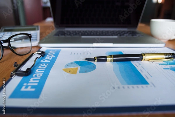 Fototapeta Pen,keyboard,calculator,report graph chart on office table,for Business.