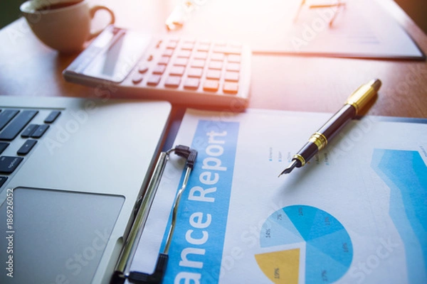 Fototapeta Pen,keyboard,calculator,report graph chart on office table,for Business.