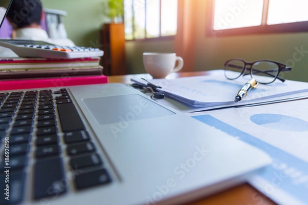Fototapeta Pen,keyboard,calculator,report graph chart on office table,for Business.