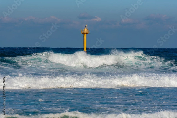 Fototapeta 노란 등대가 있는 거친 바다