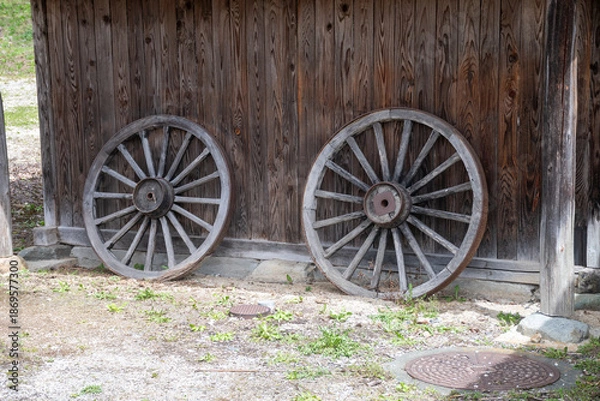 Obraz 日本の農家の納屋に立てかけられた荷馬車の車輪
